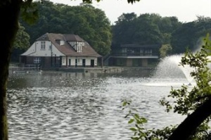 Restored whitewashed boathouse viewed from across the boating lake